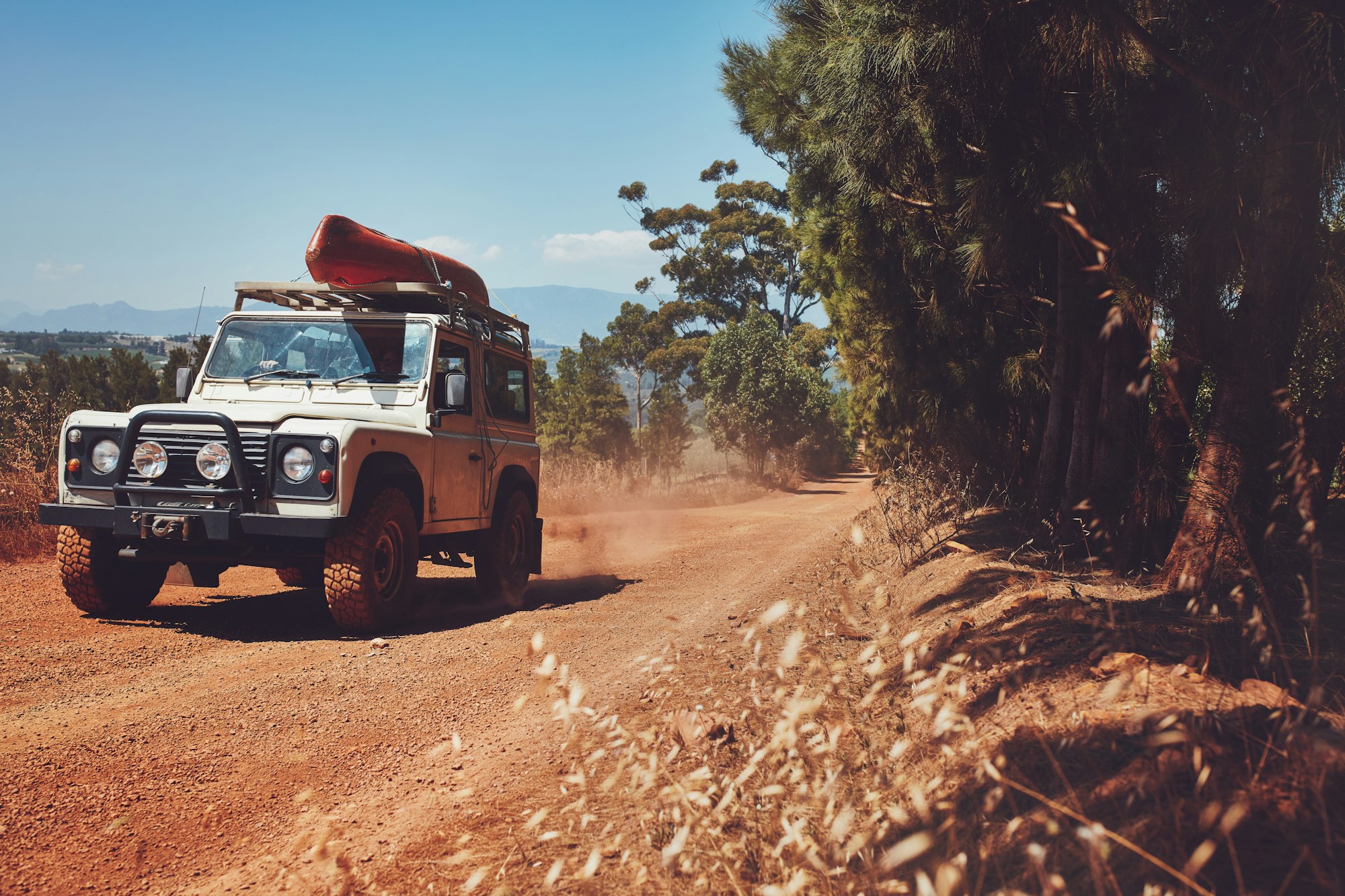 Car driving off road with canoe