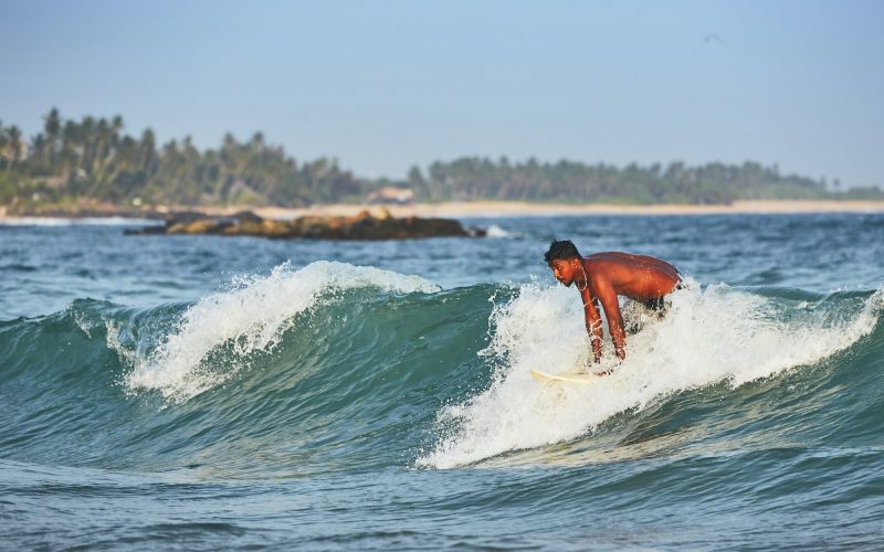 Young man surfing in sea